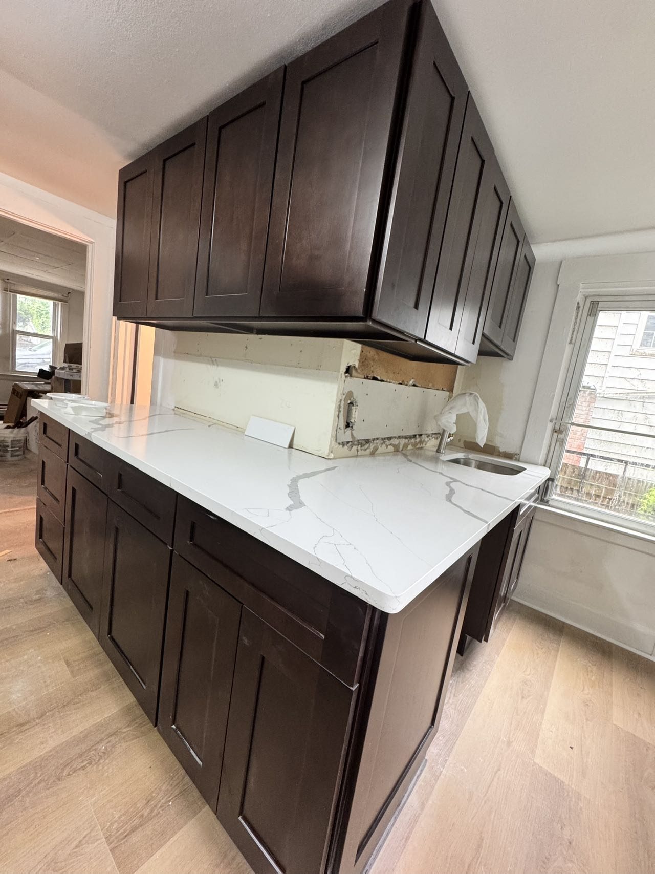 Espresso shaker cabinets topped with a white quartz countertop during a kitchen installation.