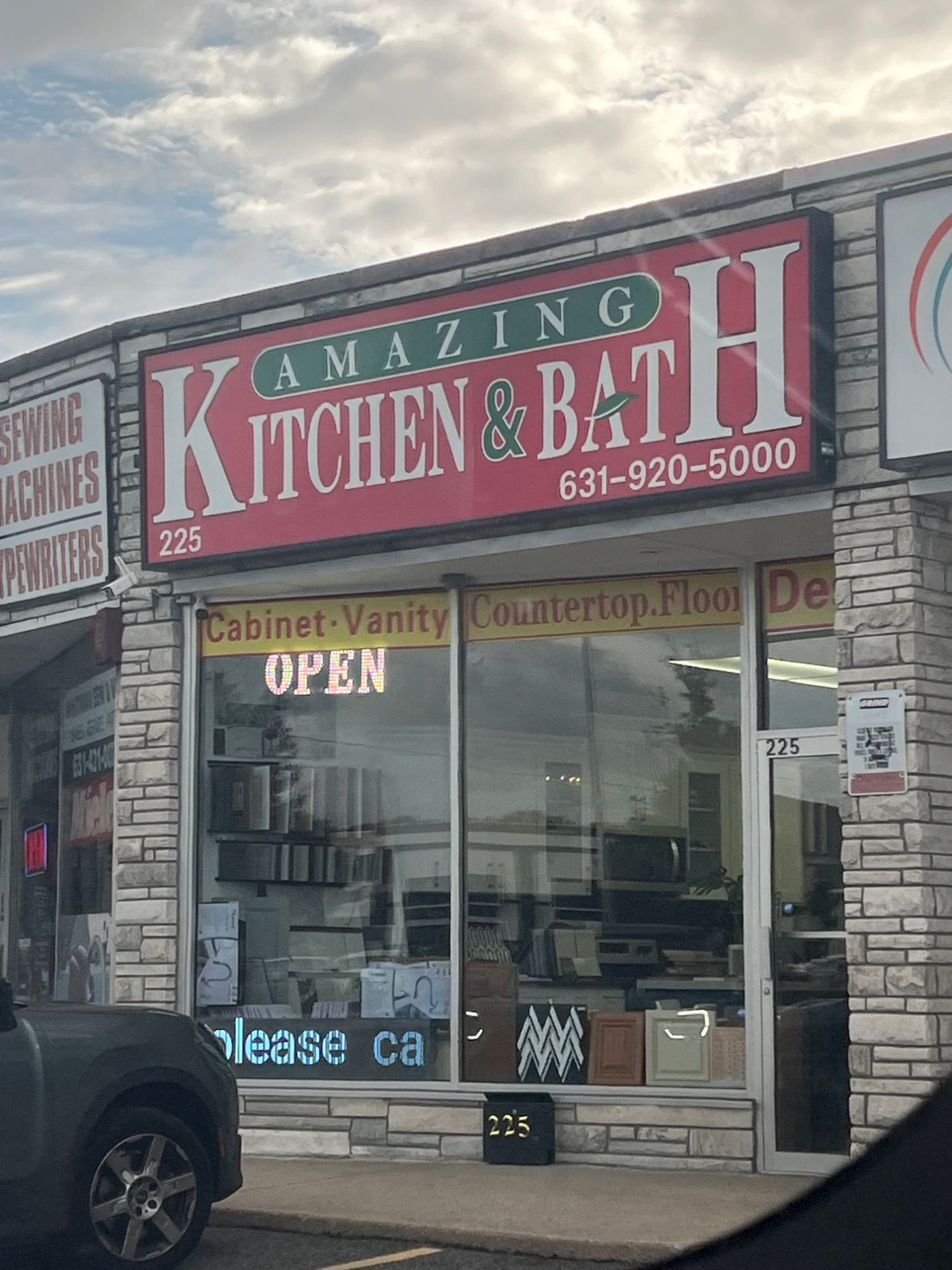 The Amazing Kitchen and Bath storefront at 225 Walt Whitman Road, Huntington Station, with cabinet doors and samples in the window.